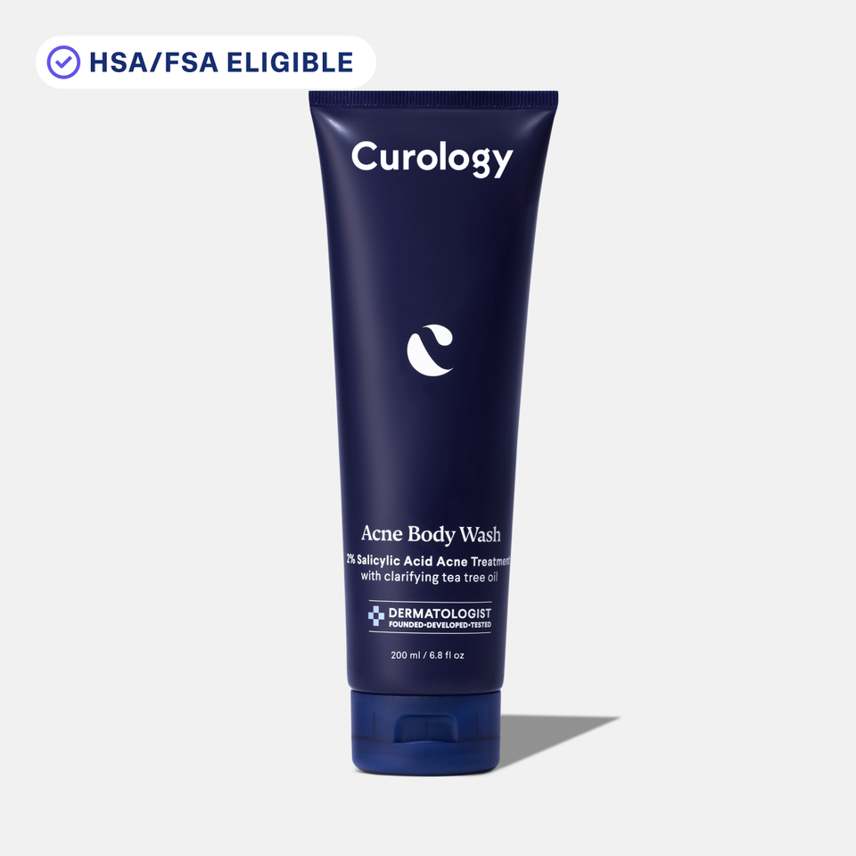 Curology Acne Body Wash in a dark blue squeeze tube with flip-top cap, labeled ‘2% Salicylic Acid Acne Treatment with clarifying tea tree oil,’ with an HSA/FSA eligible badge displayed above.